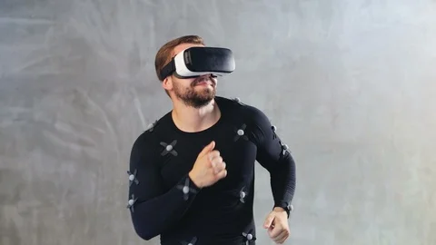 Athletic bearded man in motion capture suit having fun in virtual reality 動画素材 93592939