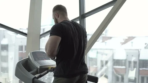 Athletic bearded man with tattoo running on a treadmill close-up 4k. Stock Footage 85716239