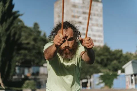 Athletic bearded man training with resistance band outdoors Foto stock