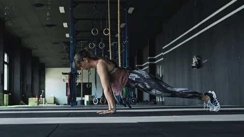 Athletic beautiful woman does push-ups in modern gym. Sportswoman exercising 스톡 동영상 110298257