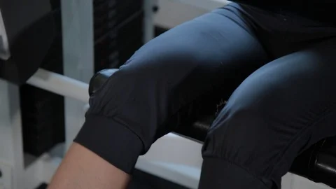 Athletic beautiful woman performs on the simulator leg extension. 库存影片 109244420