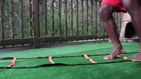 Athletic Black Man Performs Crossover Agility Ladder Drill on Turf, Closeup Stock Footage 161425157