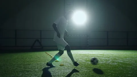 Athletic black man running in indoor football training area, practicing ball Stock Footage 229930951