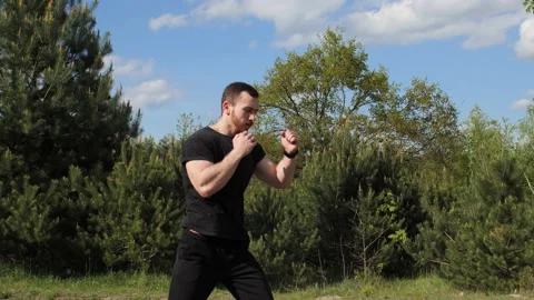 Athletic boxer practices punches with an imaginary opponent in the outdoors. Stock-Footage 131392232