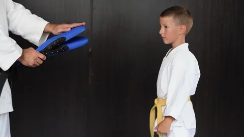 The athletic boy diligently performs straight kicks on the blue exercise machine Stock-Footage 303434050