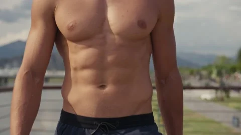 Athletic Caucasian man walking topless on the seashore after workout. Front view Vídeos de archivo 218238518