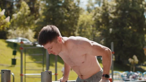 Athletic caucasian topless man practicing dips on parallel bars training triceps 動画素材 246333986