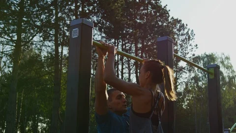 Athletic couple doing pull-ups together Stock Footage 100031242
