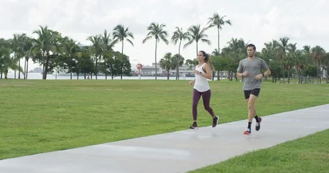 Athletic couple jogging in a park Stock Footage 97051485