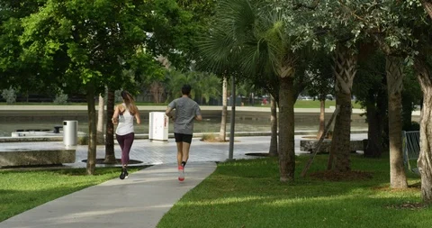 Athletic couple jogging in a park Stock Footage 97254636
