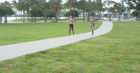 Athletic couple jogging in a park Stock Footage 97255246
