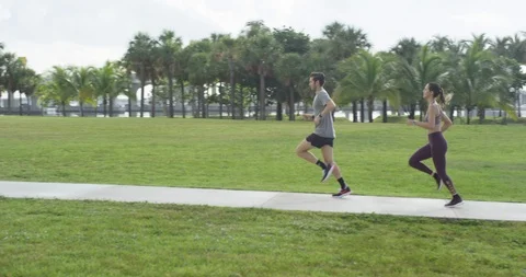 Athletic couple jogging in a park Stock Footage 97255526