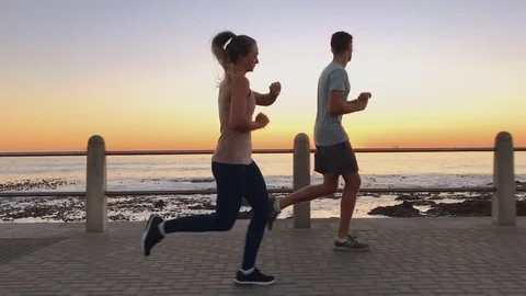 Athletic couple jogging at sunset Stock Footage