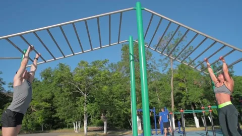 Athletic couple training together on a horizontal bars Stock Footage 91855599