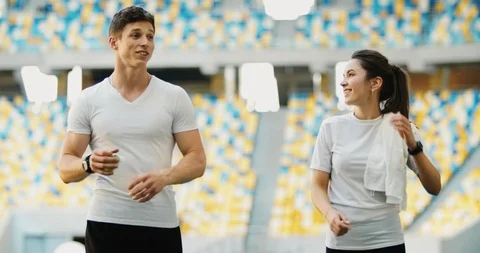 Athletic Couple Walking on Stadium 库存影片 112435040