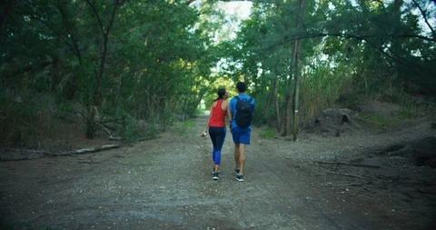 Athletic couple walking through a forrest together, shot from behind Stock Footage 104231726