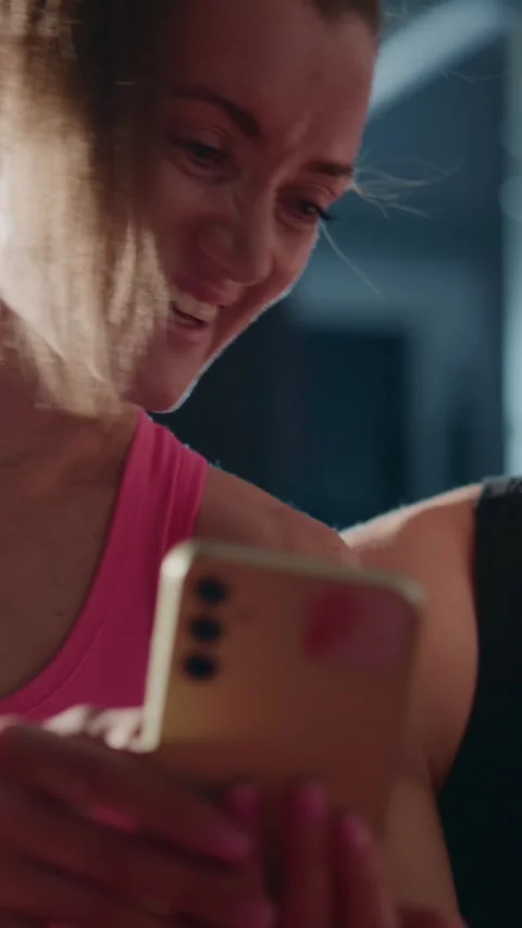 Athletic duo checking smartphone in gym, laughing and interacting Stock Footage 335506046
