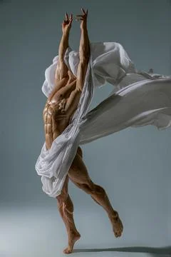 Athletic faceless man posing in a studio with a white cloth in an original way Foto stock