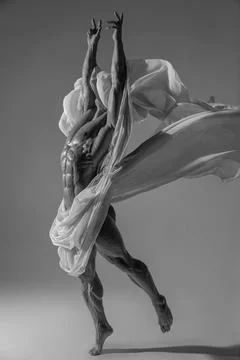 Athletic faceless man posing in a studio with a white cloth in an original way Stock Photos