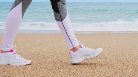 Athletic feet walking on the beach, the camera moves over the feet Stock Footage 134868144