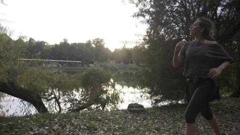 Athletic female instructor jogging in the park to tone her body and increase  Stock Footage 83316604