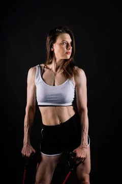 Athletic female performs exercises using a resistance band. Strength and Stock Photos