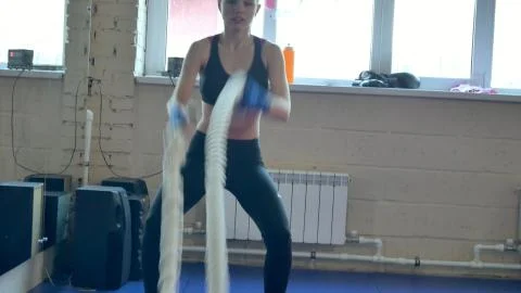 Athletic Female Working Out Using Battle Ropes. High-intensity interval training Stock Photos