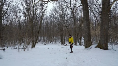 Athletic fit man warming up during snowfall in winter forest with free space Stock Footage 105375464