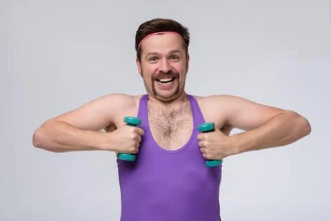 Athletic funny young man doing exercise dumbbell Stock Photos