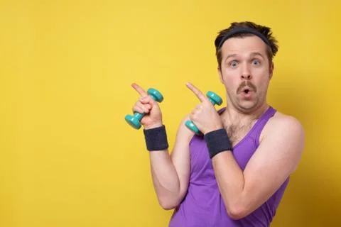 Athletic funny young man doing exercise dumbbell Stock Photos