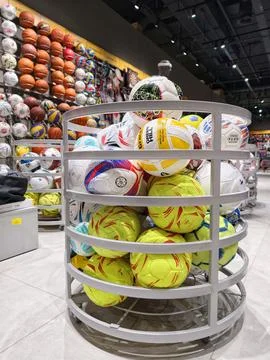 Athletic game balls of different brands arranged on store display racks in .. Stock Photos