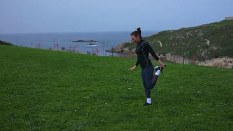 An athletic girl does physical exercises in the fresh air. Stock Footage 186739369