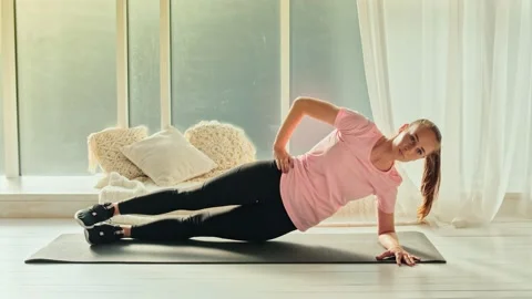 An Athletic Girl Doing Side Plank Core Strength Training at Home Alone. Sport Video stock 139051742