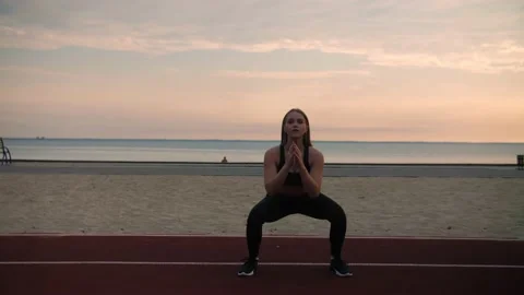 Athletic girl doing squats with her weight on the beach.Girl working out Stock Footage 208376338