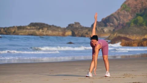 Athletic girl doing warm-up on the ocean shore Stock Footage 265878813