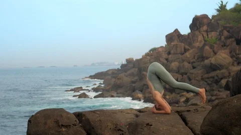 Athletic girl into headstand pose on flat stone slow motion Vidéo 112270239