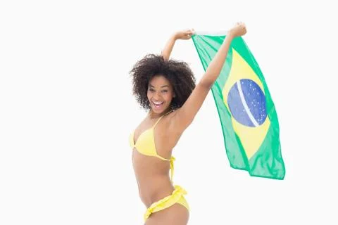 Athletic girl in yellow bikini holding brazil flag Stock Photos