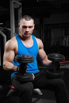 Athletic guy bodybuilder , execute exercise with dumbbells Stock Photos
