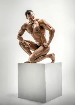 Athletic guy - bodybuilder,   pose on gray background Foto stock
