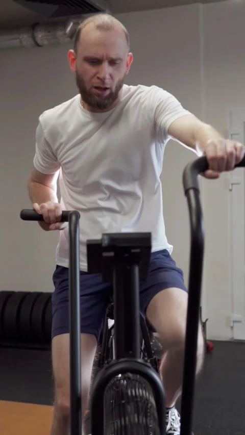 Athletic guy doing cardio workout on exercise bike. Motivation and strength. Stock Footage 302432975