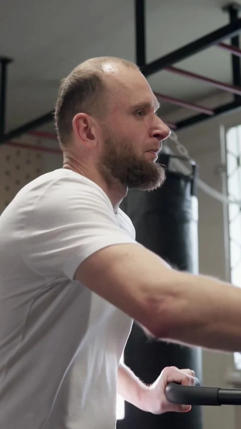 Athletic guy doing cardio workout on exercise bike. Motivation and strength. Stock Footage 302433079