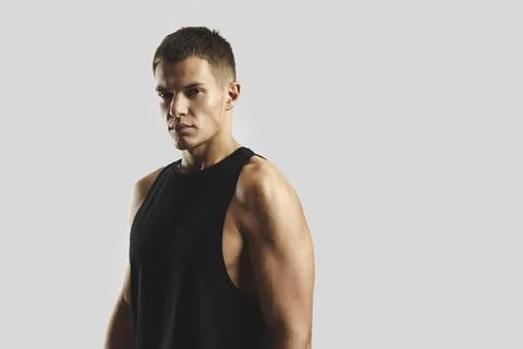 Athletic guy Posing in Black Tank Top Against a light gray Background Stock Photos