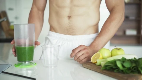 Athletic guy pours smoothie into a plastic glass and drink Stock Footage 94117205