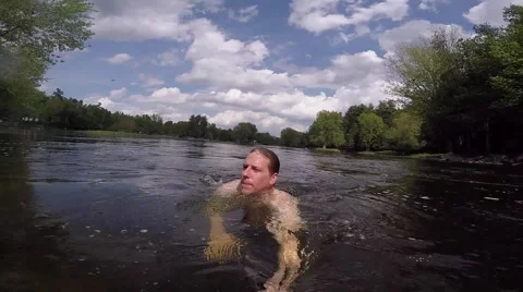 Athletic guy swimming up stream Stock Footage 50939478