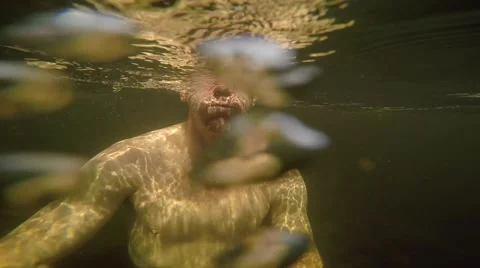 Athletic guy swims in rocky stream slow motion Stock Footage 50942139