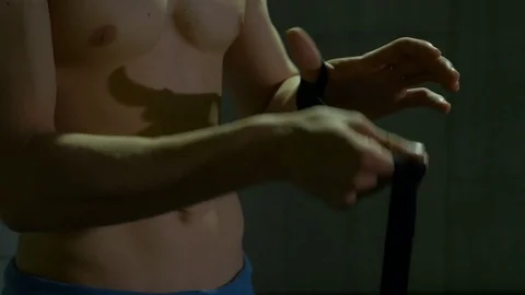 Athletic kickboxer wrapping punching bandage on his hand preparing for compet Stock Footage