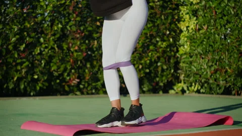 Athletic lady training with rubber bands while staying in the park Stock Footage 154276760