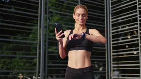 Athletic lady using fitness tracker application during outdoor workout Video stock 252199216