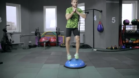 Athletic man in activewear doing side lunge exercised on Bosu Stock Footage 147058167