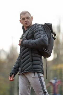 Athletic man with backpack posing on sports ground outdoors Stock Photos